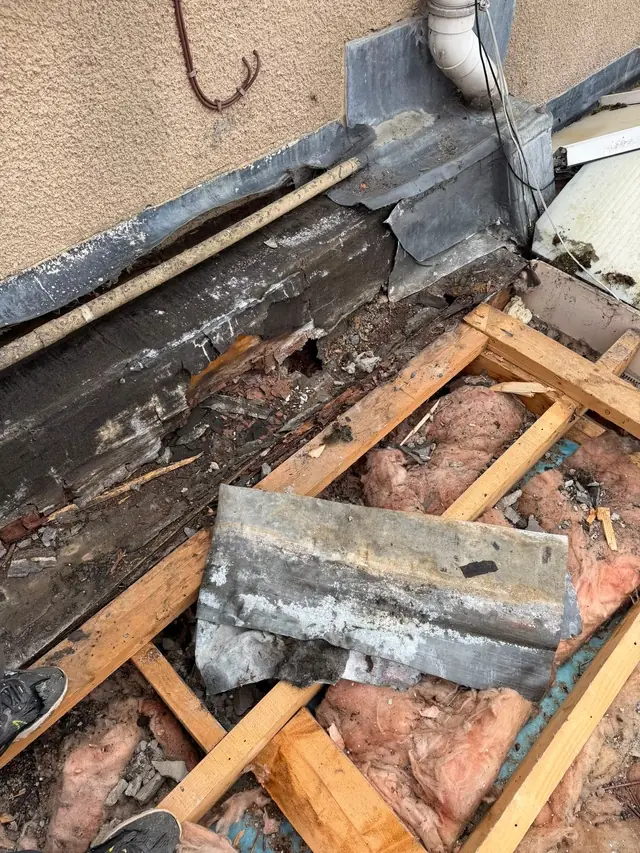 Old timbers and lead flashing exposed while stripping a roof