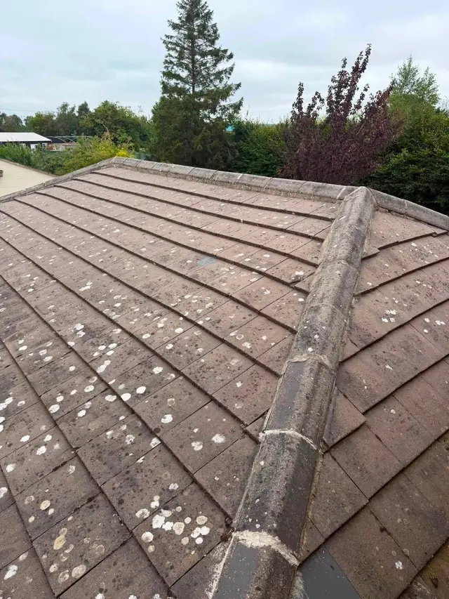 Finished brown and grey tiled hipped roof close up