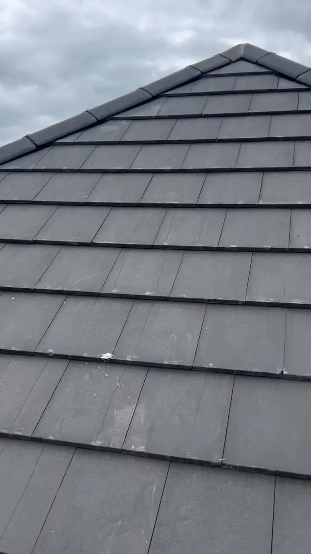 Close up of newly laid flat profile grey roof tiles