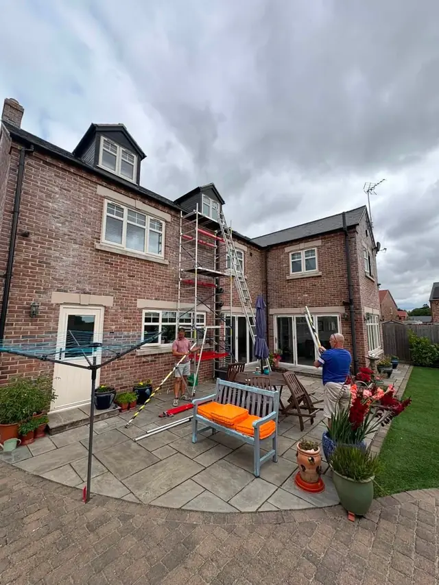 Scaffolded house seen from the garden during roofing work