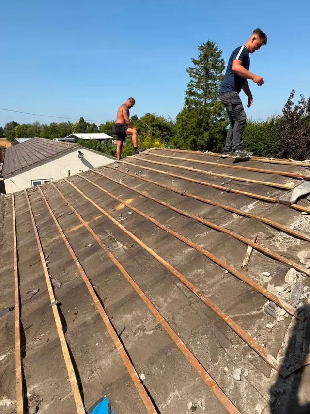 Roofer working along the ridge of a stripped and re-battened roof